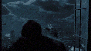 a person looking out of a window at night