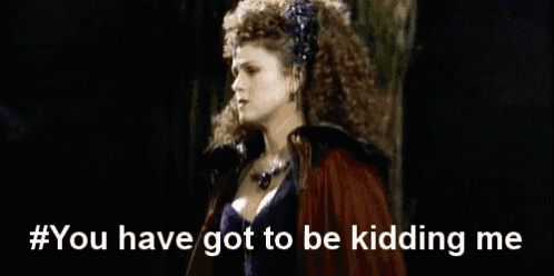 a woman with curly hair is wearing a red cape and a crown and says you have got to be kidding me