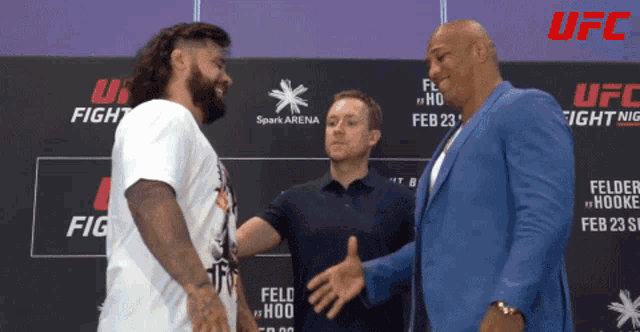 two men stand in front of a sign that says ufc fight night