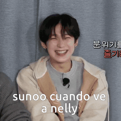 a young man is smiling with the words " sunoo cuando ve a nelly " behind him