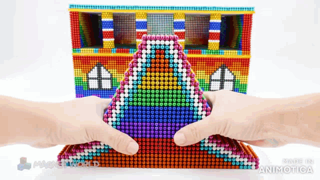 a person is holding a pyramid made of magnets