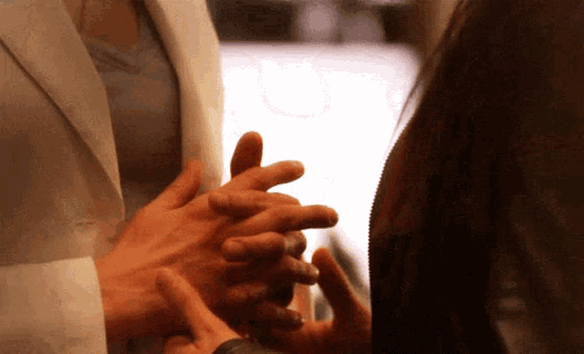 a man and a woman holding hands with their fingers crossed