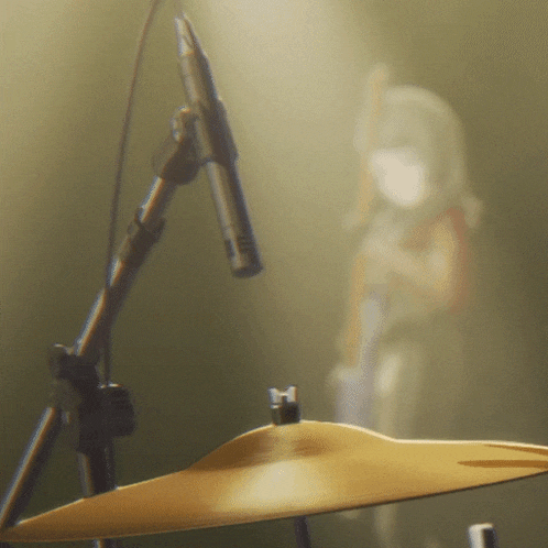 a drum set with a drum cymbal and a microphone in the background