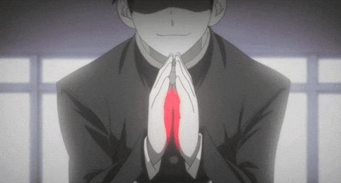 a man in a suit is praying with his hands folded in front of him