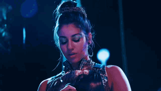 a woman wearing a crown and earrings is holding a fan in her hand