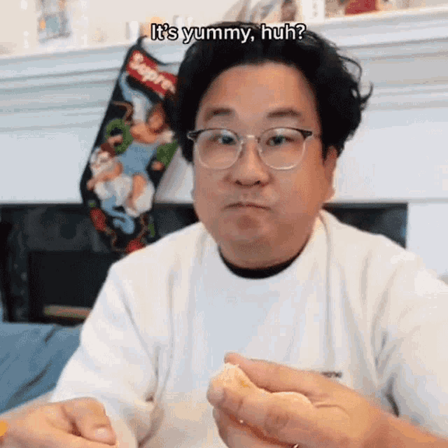a man wearing glasses and a supreme shirt is eating food