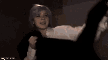 a person in a white shirt is standing in a dark room surrounded by smoke