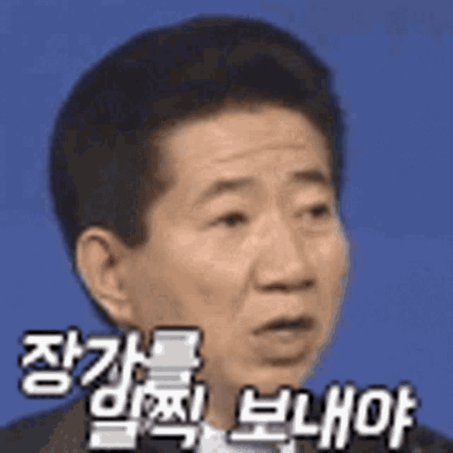 a man in a suit and tie is making a funny face with chinese writing on his face .