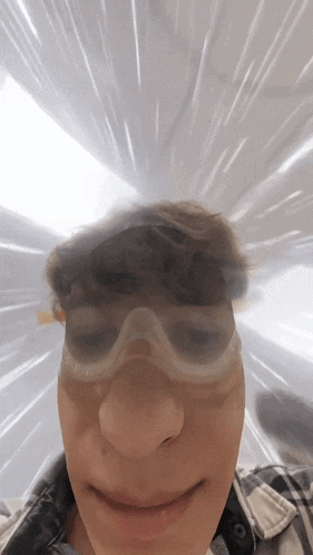 a close up of a person 's face wearing goggles and headphones