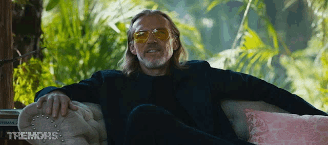 a man wearing sunglasses sits on a couch with the words the moros written on the bottom