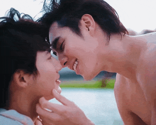 a couple of men are touching each other 's faces and smiling .