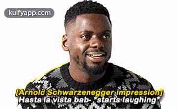 a man with a beard is wearing a black and white sweater and is laughing .