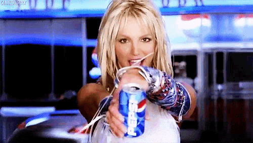 britney spears is holding a can of pepsi with a straw .