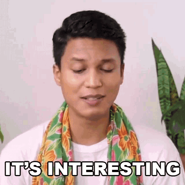 a man with a scarf around his neck is making a funny face and saying `` it 's interesting '' .