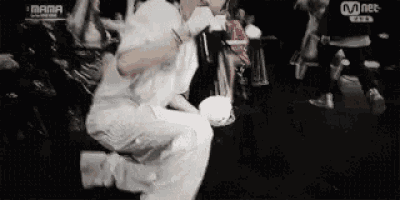 a man in a white shirt is kneeling down in a crowded room .