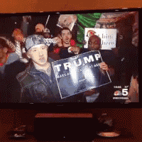 a man holding a sign that says trump