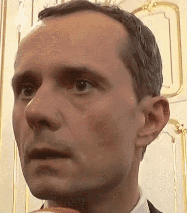 a close up of a man 's face with his mouth open and a serious look on his face .