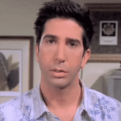 a close up of a man 's face with a floral shirt