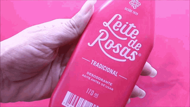 a woman holds a bottle of leite de rosas deodorant