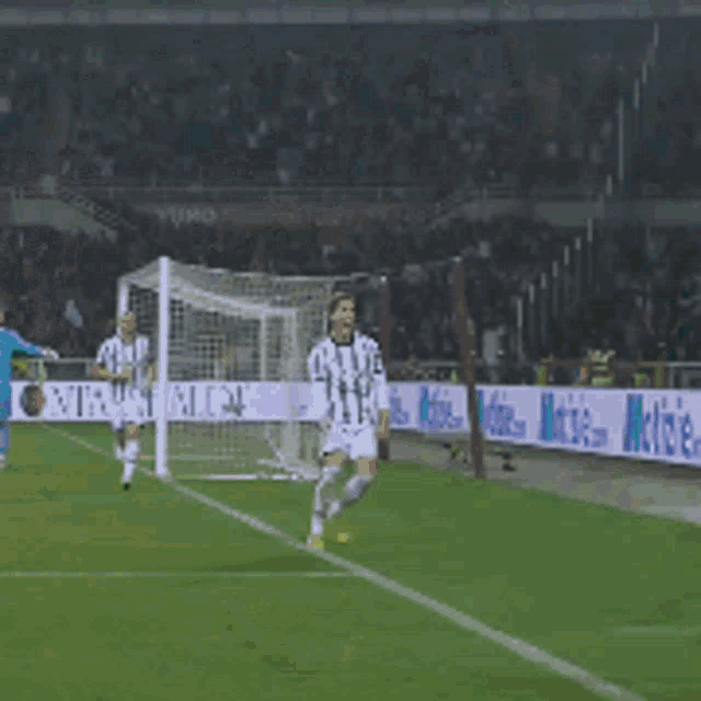 a soccer player jumps in the air in front of a banner that says notizie