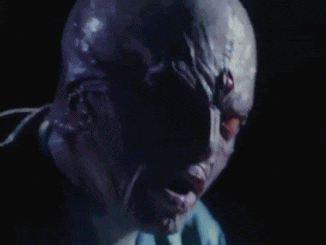 a close up of a person 's face with a shadow of a person behind it