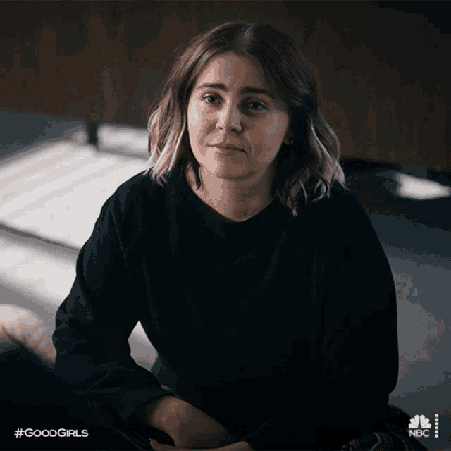 a woman in a black shirt is sitting on the floor