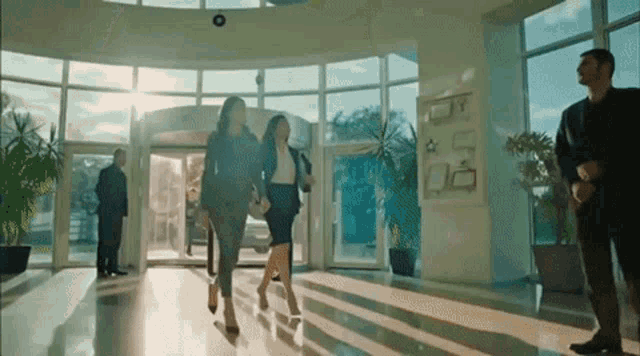 a group of people are walking down a hallway in a building .
