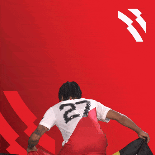 a man holding a flag with a jersey that says ' ucl ' on it