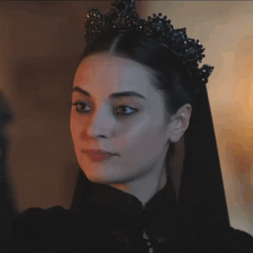 a woman wearing a black dress and a black tiara on her head