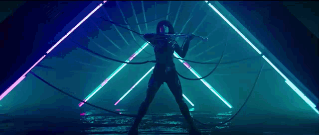 a woman is playing a violin in a dark room surrounded by neon lights