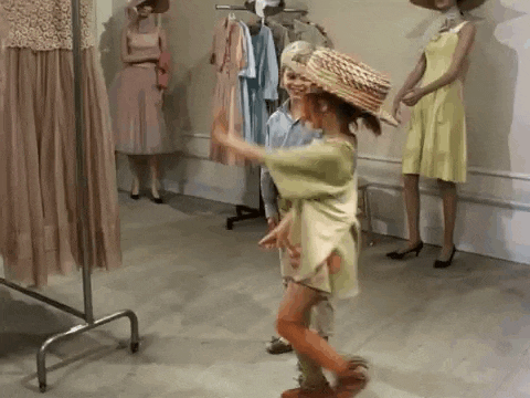 a boy and a girl are dancing in front of mannequins in a store