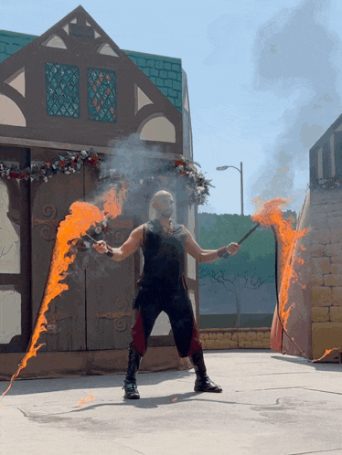 a man in a black tank top is holding a fire stick