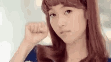 a young woman is making a fist with her hand .