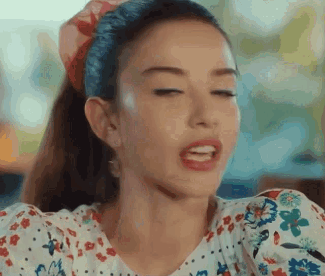 a close up of a woman 's face with her eyes closed and a headband on her head