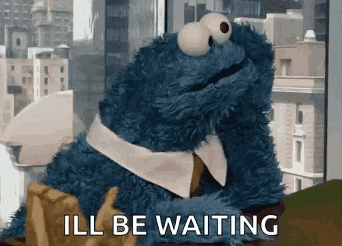 cookie monster from sesame street is sitting at a table with french fries and says i 'll be waiting .