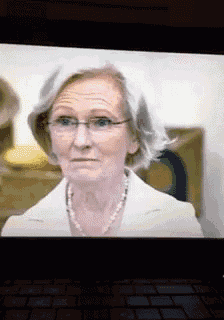 a close up of an older woman wearing glasses