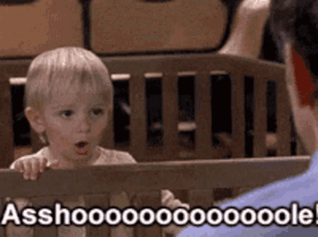 a little boy in a crib with the words asshoooo written on the bottom