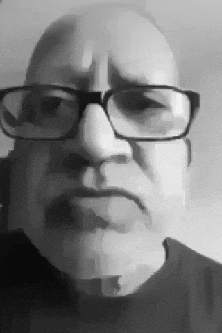 a black and white photo of a man wearing glasses .