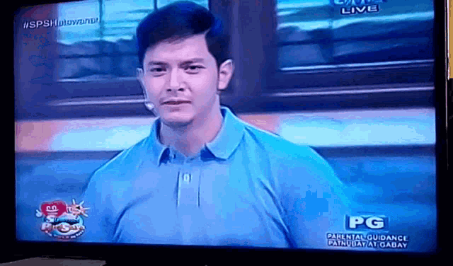 a man in a blue shirt is on a tv screen with pg written on it