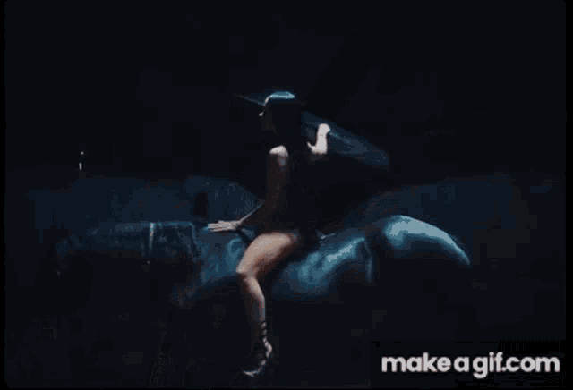 a woman with long black hair is laying on a bed with make a gif.com in the lower right corner