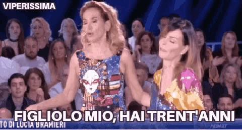 two women are dancing in front of a crowd and one of them says figliolo mio