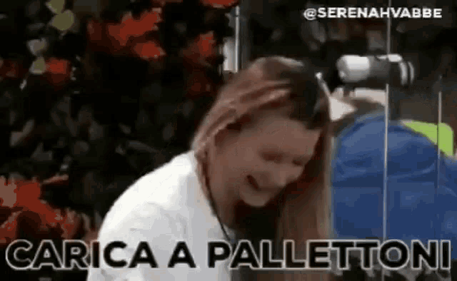 a woman is sitting in front of a microphone with the words carica a pallettoni written on it .