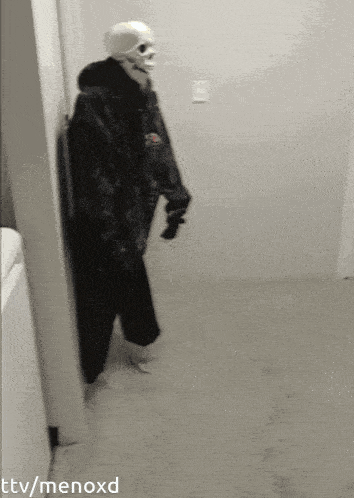a person in a skeleton costume is leaning against a wall in a room