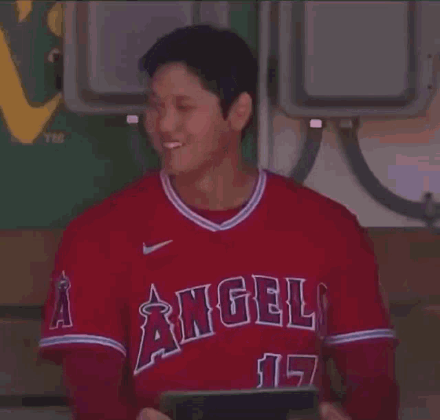 a man wearing a red angels jersey with the number 17 on it
