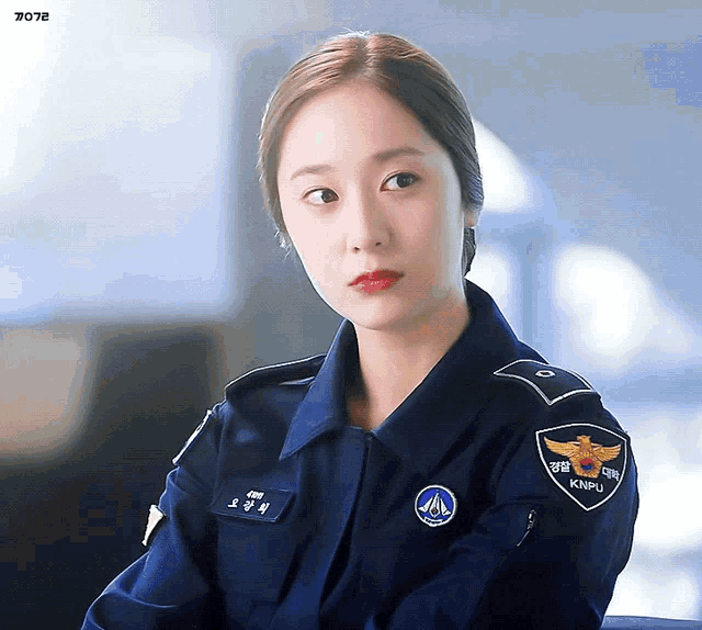 a woman in a police uniform has a patch that says knpu