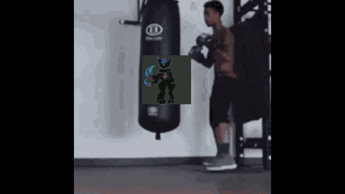 a man is standing in front of a punching bag with a picture of a monster on it .