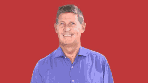 a man in a blue shirt is smiling for the camera