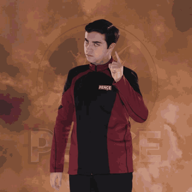 a man wearing a red and black jacket with pence on it