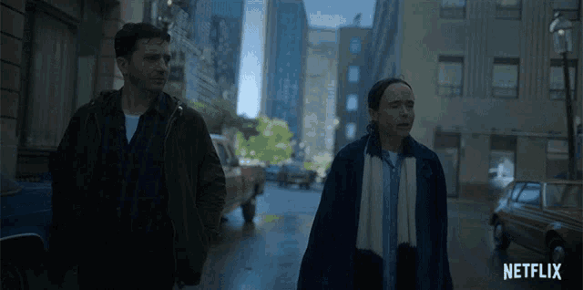 a man and a woman are walking down a city street with a netflix logo in the corner