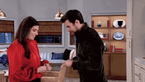 a man and a woman are standing next to each other in a room